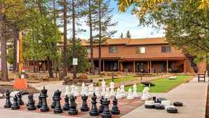 A chessboard set up outdoors with a building in the background. - Pine-Grand Canyon by Roundhouse Resort and Spa (Pinetop Country Club)