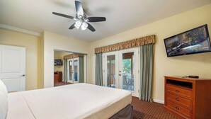 A hotel room with a bed, a TV, a desk, and a window with curtains. - Pine-Grand Canyon by Roundhouse Resort and Spa (Pinetop Country Club)