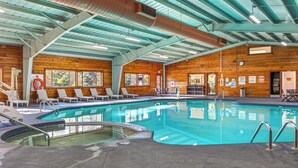 A large indoor swimming pool with a wooden interior, lounge chairs, and a hot tub. - Pine-Lodge by Roundhouse Resort and Spa (Pinetop Country Club)