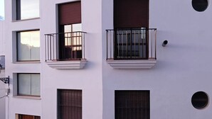 Ein mehrgeschossiges Gebäude mit Balkonen, Fenstern und einer Tür.
