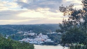 Ein Steinweg führt zu einer Aussichtsplattform mit Blick auf eine Stadt und einen Fluss.