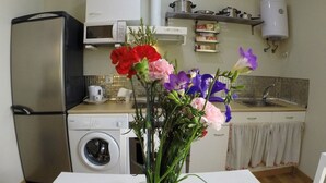 A kitchen with a washing machine, a refrigerator, a microwave, and a sink. - DiscoverHome Sacramento (Cádiz)