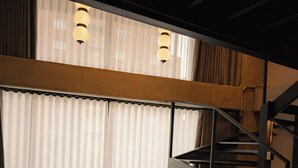 Un interior moderno con una escalera, una mesa redonda y un sofá.