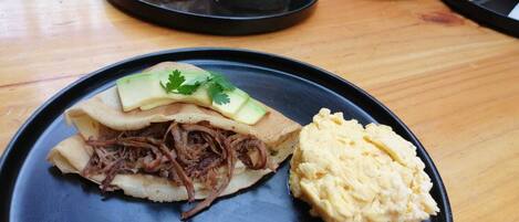 Ein Teller mit einem Sandwich, Kartoffelstampf und Rührei.