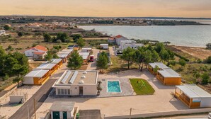 A coastal residential area with modern houses, a swimming pool, and a view of the sea. - PREMIUM HOLIDAY HOUSE 3 (Privlaka)