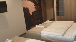 Une chambre d’hôtel avec deux lits, chacun agrémenté d’une serviette soigneusement pliée.