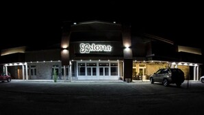 Un bâtiment sur lequel on peut lire l’inscription « Stona », et un parking avec des voitures.