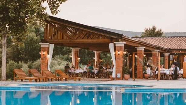 Un restaurant situé au bord de la piscine, avec une terrasse et une piscine.