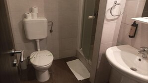 Un baño con inodoro, ducha y lavamanos.