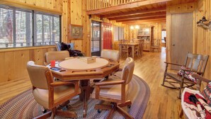 A wooden cabin interior with a dining area, kitchen, and a cozy living space. - Bear's Den 2 Mi to Pinetop CC: Ski, Sled, Hike! (Pinetop Country Club)