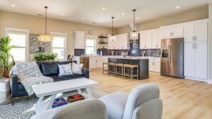 A modern kitchen with white cabinets, stainless steel appliances, and a central island. - Walk to Water & Greenway! Luxe Carolina Beach Home (Carolina Beach)