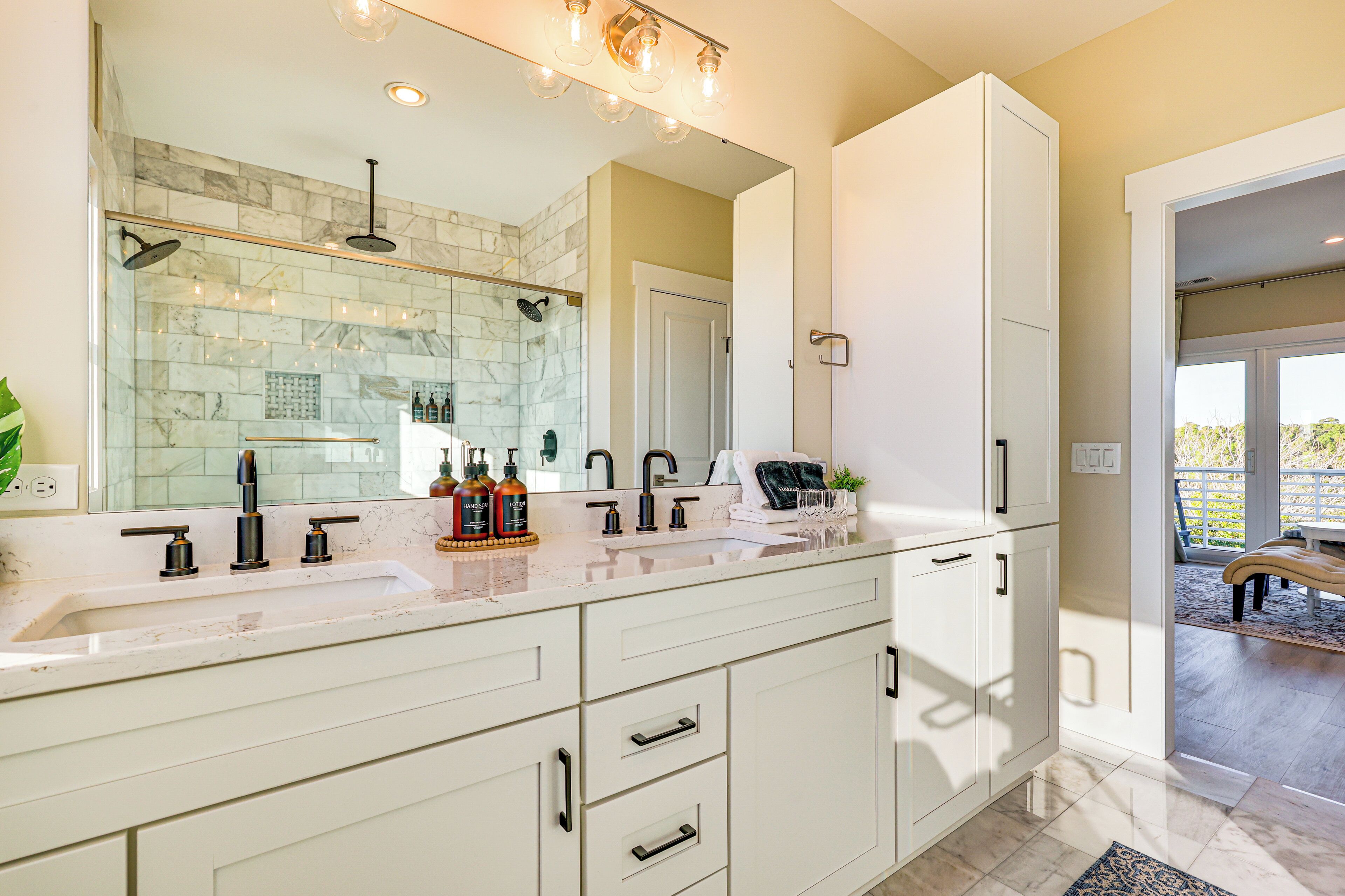 A modern bathroom with a double sink, a large mirror, and a shower area.