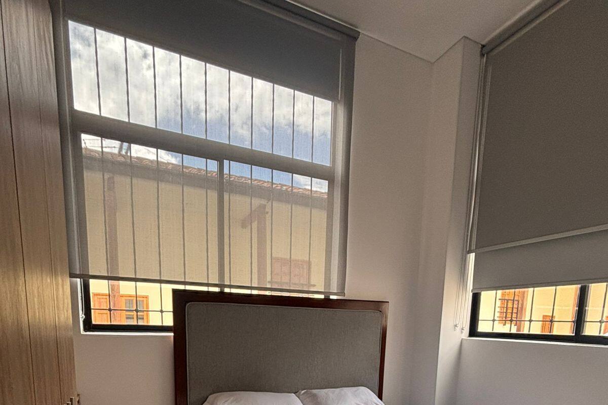 A bedroom with a bed, a window, and a wardrobe.
