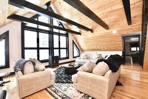Un vaste salon de style loft, doté de hauts plafonds, de grandes fenêtres et d’une cheminée chaleureuse.