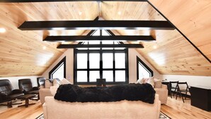 Un dormitorio tipo loft acogedor con un ventanal grande, un sofá y una zona de escritorio.