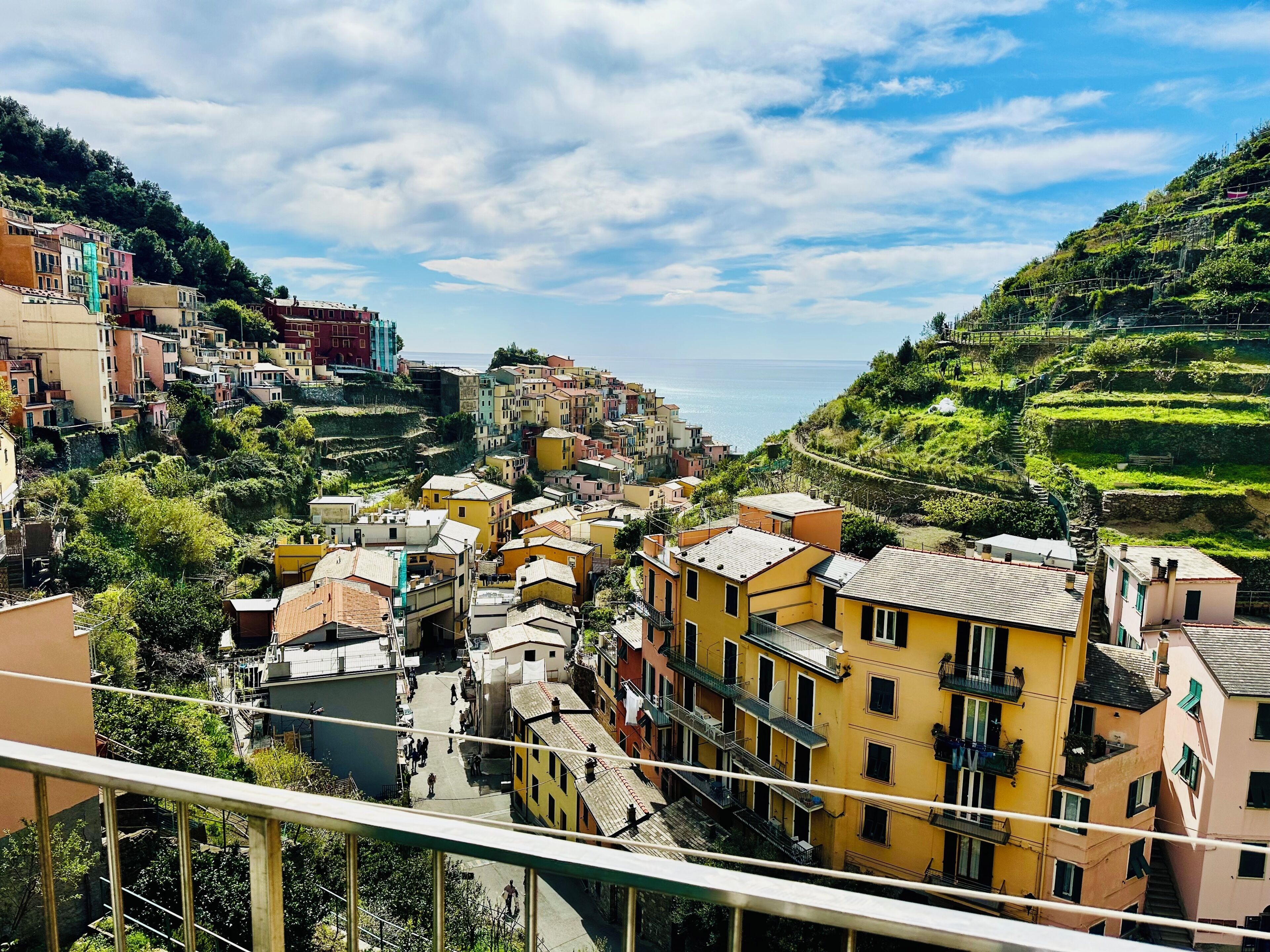 A coastal town with terraced houses, a visible street, and a clear view of the sea.