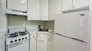 Eine Küche mit weißen Schränken, einem Herd, einer Spüle und einem Kühlschrank.