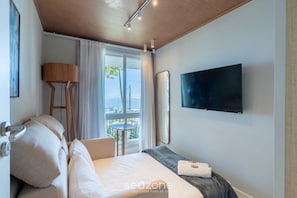 Une chambre d’hôtel avec un lit, une télévision, une fenêtre avec des rideaux et une vue sur l’extérieur.
