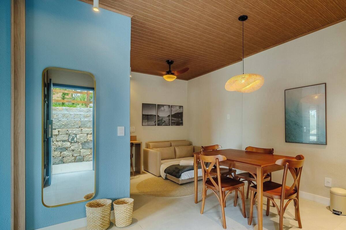 A modern interior with a dining area, a sofa, and a bed.