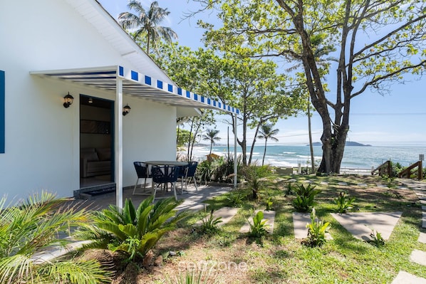 Une maison moderne dotée d’un patio couvert donnant sur l’océan.
