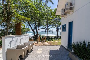 A beachside building with outdoor sinks and a view of the ocean. - Beachfront Condominium in Morro das Pedras - Ftss (Florianópolis)