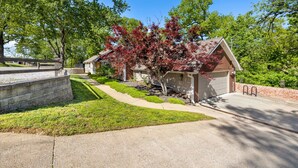 Une propriété résidentielle dotée d’une allée, d’un garage et d’une pelouse bien entretenue.