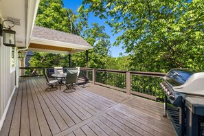 A wooden deck with a grill, outdoor furniture, and a covered area. - Almand House-ON MTB Trail-Hot Tub-Epic Gameroom (Bentonville)