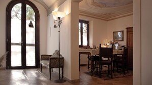 A spacious room with a large arched doorway, a dining area with a table and chairs, and a decorative lamp. - Self-contained apartment with independent access in Farmhouse. (Toscana)
