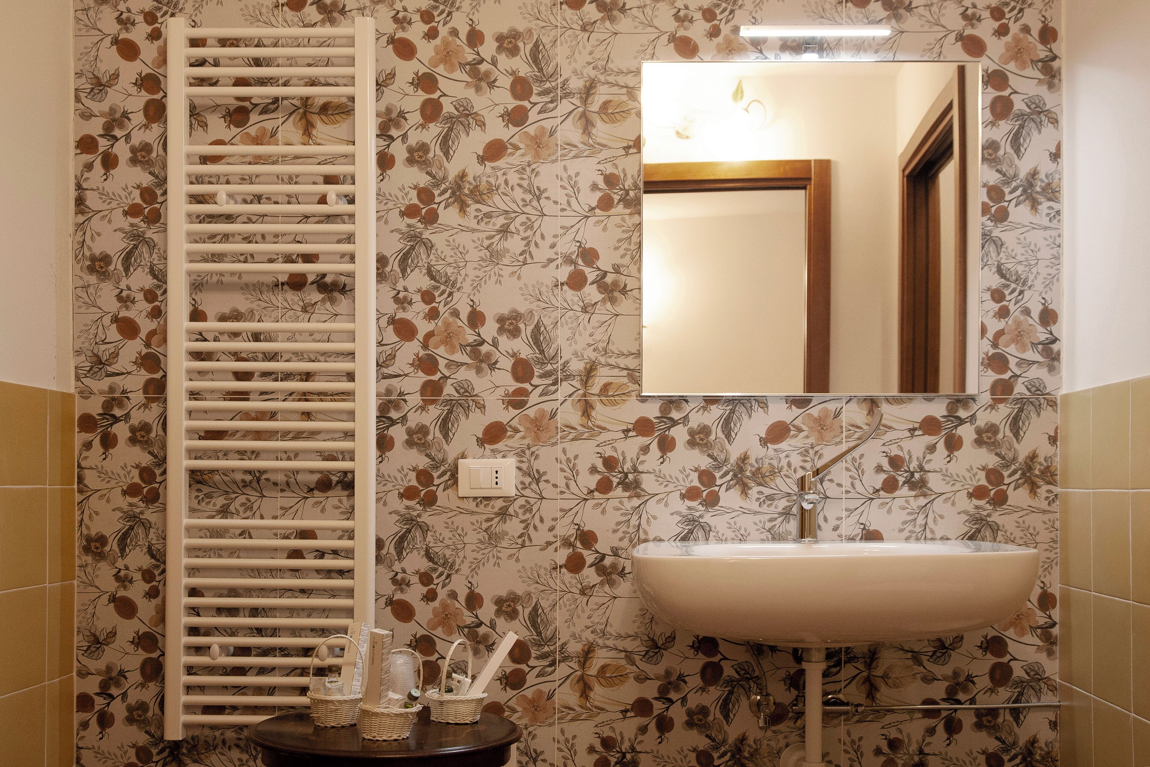 A bathroom with a white towel rack, a sink, and a mirror.