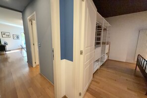 Een gang met een witte deur, een blauwe muur en een witte trap.