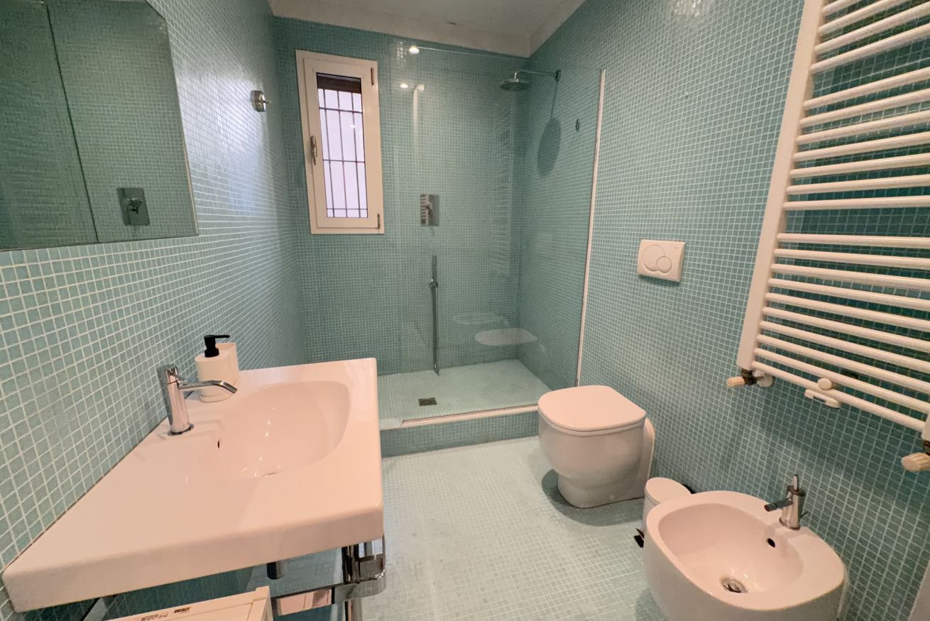 A bathroom with a sink, toilet, and shower area.