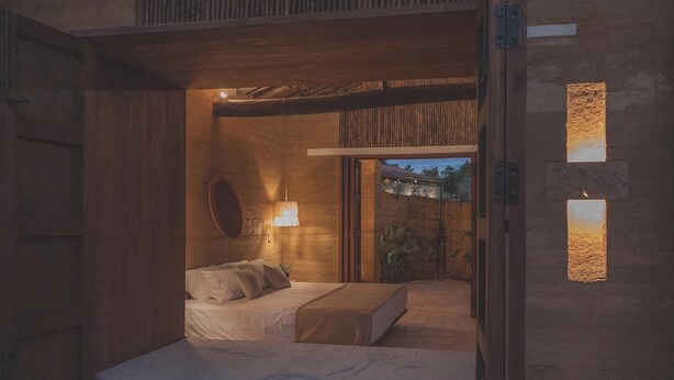 A cozy bedroom with a bed, a nightstand, and a lamp. - Hotel Ambil (Barichara)