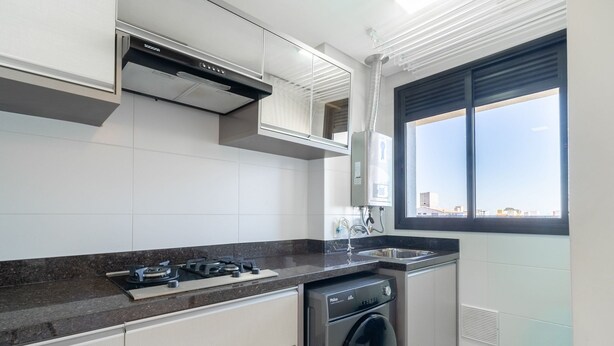A modern kitchen with a gas stove, built-in oven, and a washing machine. - Fully Equipped apt Near the Beach Rcq0305 (Florianópolis)
