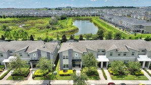 A residential area with modern houses, a central pond, and well-maintained lawns. - Magical Retreat at Championsgate (Davenport)
