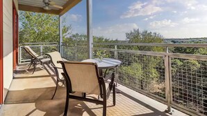 A covered balcony with a table and chairs, offering a view of trees and distant buildings. - Charming 1-bedroom villa with AC in fantastic San Antonio (San Antonio)