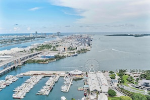 A marina with boats, a Ferris wheel, and a bridge. - Miami Events Hub | Oceanfront Downtown Residence (Miami)