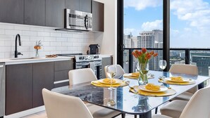Eine moderne Küche mit Essbereich, großen Fenstern und Blick auf die Stadt.