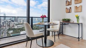 Un espace de restauration moderne avec un balcon offrant une vue sur le paysage urbain et une table dressée pour deux personnes.