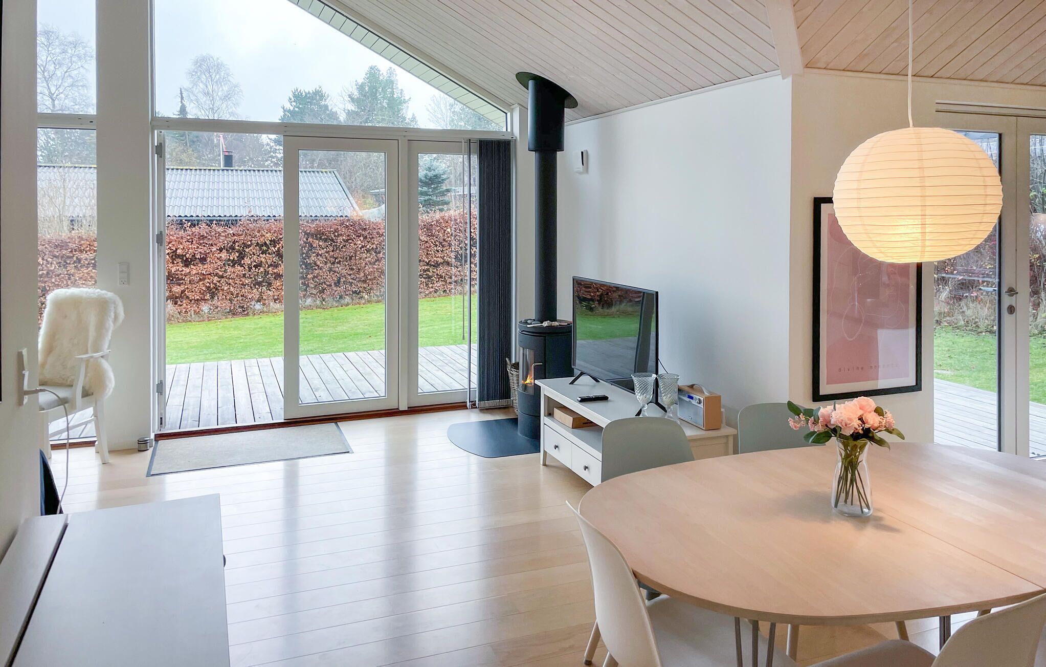 Ein modernes Wohnzimmer mit Fernseher, Kamin und Essbereich mit Tisch und Stühlen.