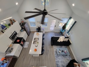 A modern kitchen with a central island, white cabinetry, and a ceiling fan.