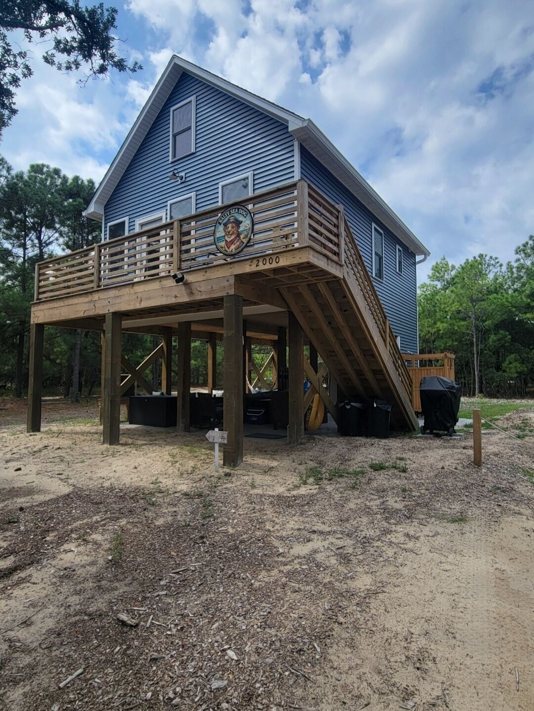 A two-story house with a wooden deck and a covered area.