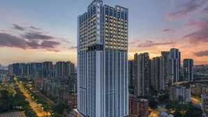 A high-rise hotel with a modern design, featuring a prominent vertical structure and numerous windows. - Four Points By Sheraton Guangzhou Bai’E Tan (Guangzhou)