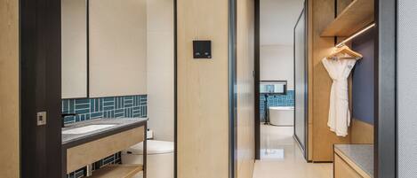 A modern bathroom with a wooden vanity, a mirror, and a towel rack.
