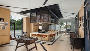 A modern bar area with a foosball table, bar stools, and a counter with a menu. - Four Points By Sheraton Guangzhou Bai’E Tan (Guangzhou)