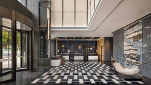 A modern lobby with a checkered floor, a reception desk, and a large wall art installation. - Four Points By Sheraton Guangzhou Bai’E Tan (Guangzhou)