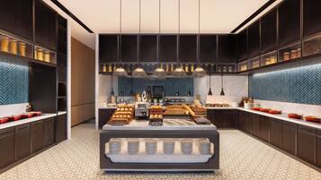 Una cocina moderna con una isla central, iluminación colgante y un salpicadero con diseño.
