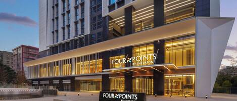 Ett modernt hotell med en tydlig skylt som visar att det tillhör kedjan ”Four Points by Sheraton”, med en stilren fasad och en upplyst entré.