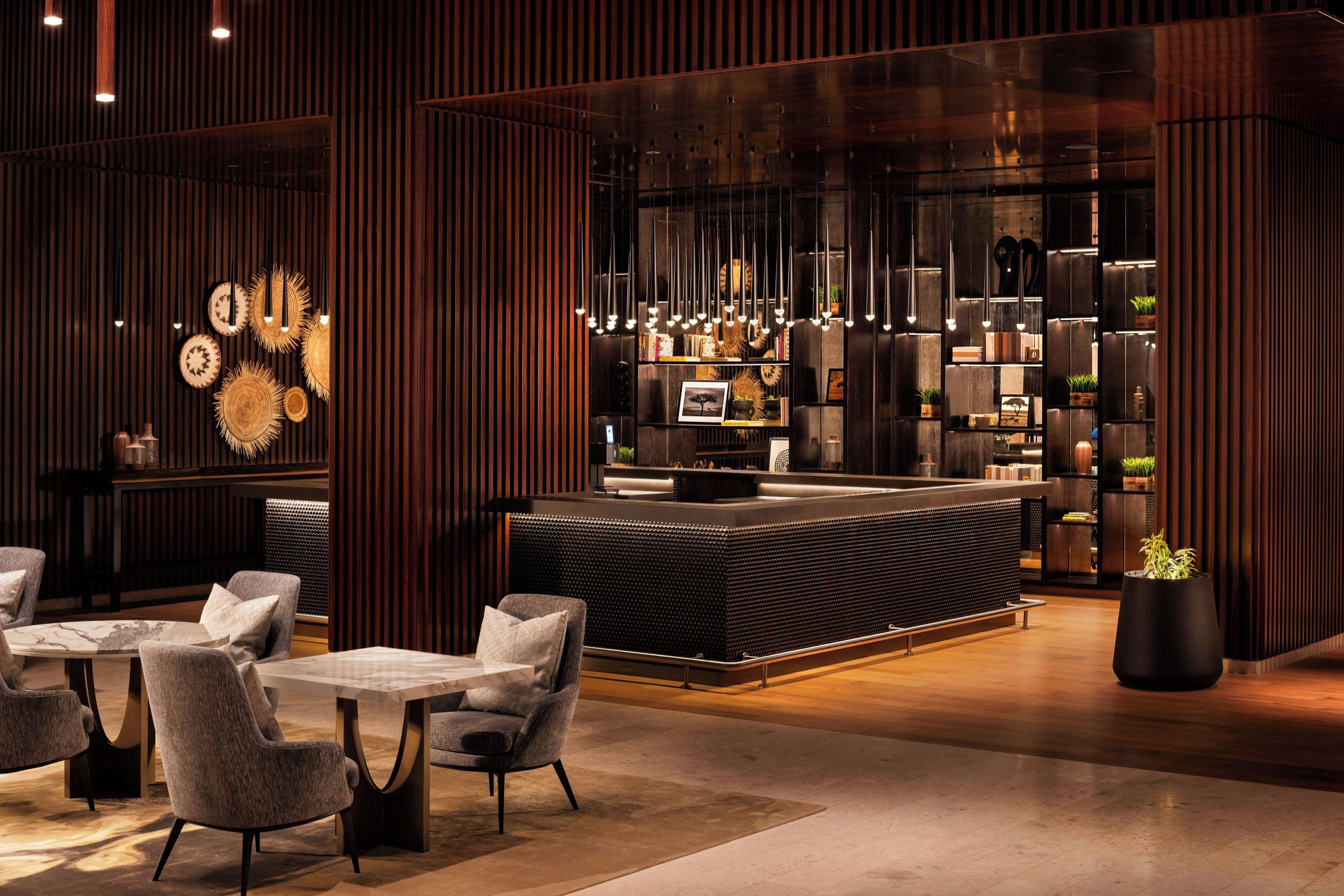 A modern interior with a reception desk, seating area, and decorative wall panels.