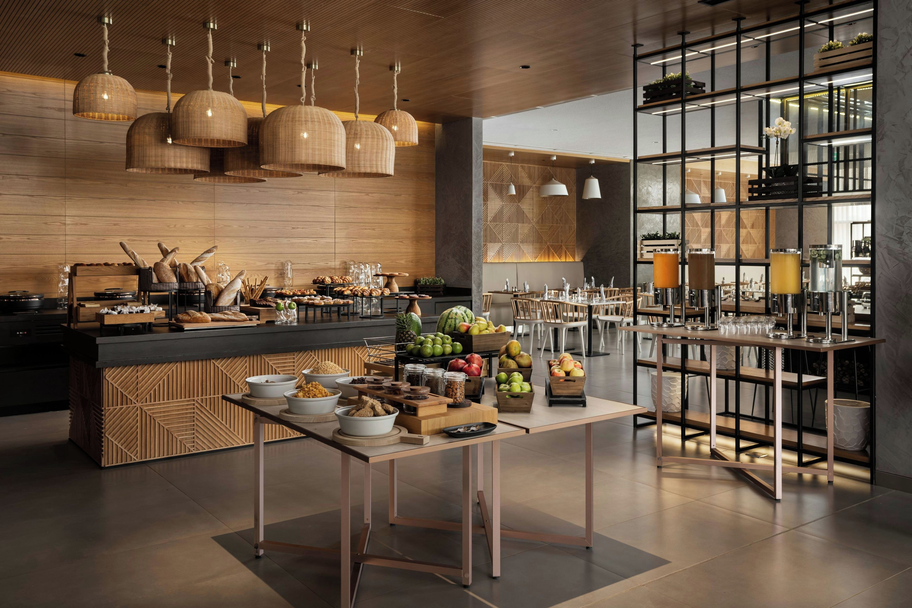 A modern restaurant interior with a central serving counter, seating area, and a bar.