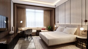Een moderne hotelkamer met een groot bed, een slaapbank, een bureau en een televisie.